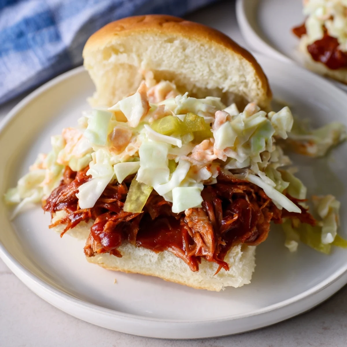 Golden-brown BBQ jackfruit sliders overflowing with tender, savory vegan pulled "pork" and slaw.