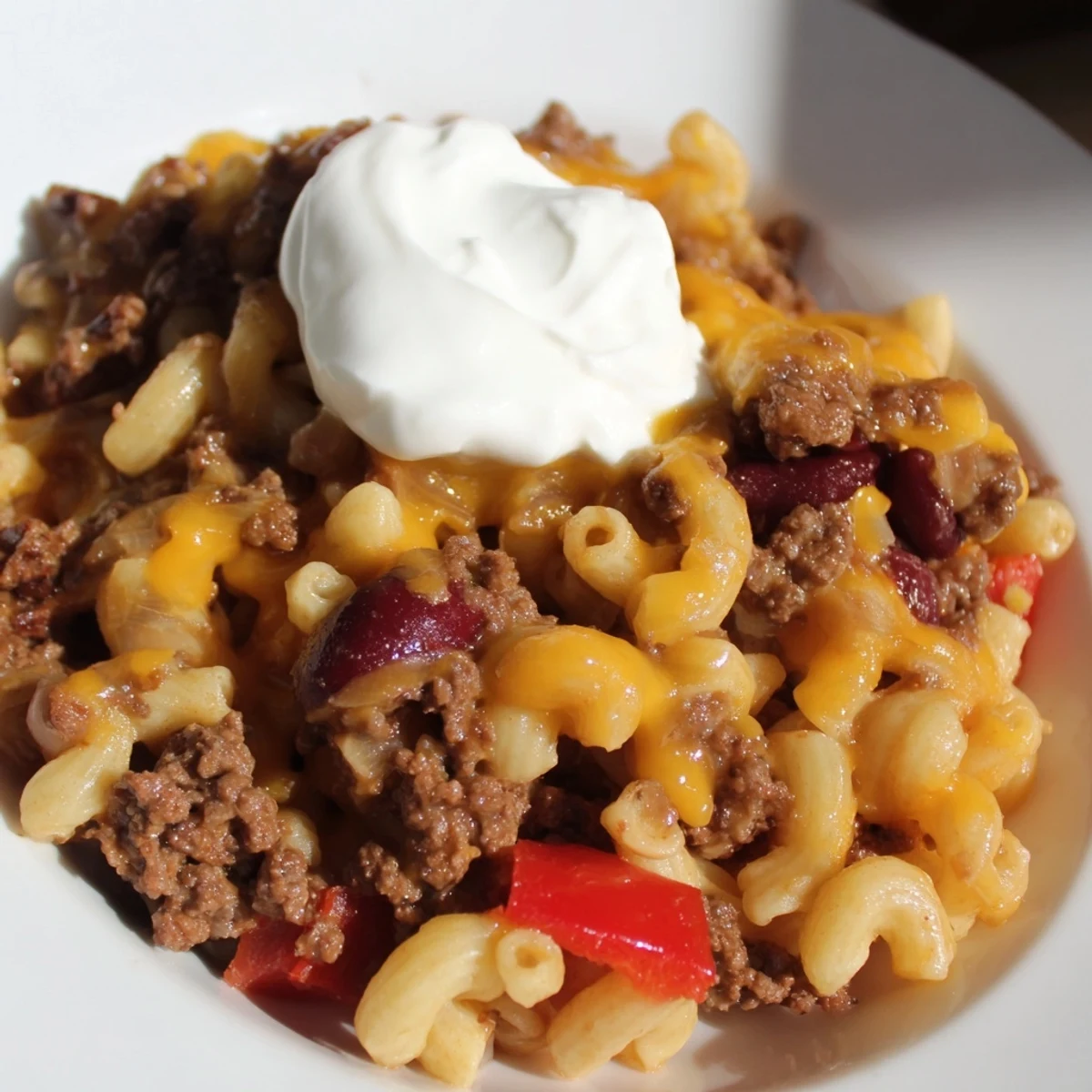 A steamy bowl of One-Pot Chili Mac, garnished with melted cheese, ready to be enjoyed.