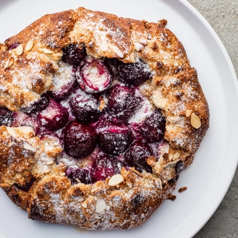 Golden-crusted Rustic Cherry and Vanilla Almond Galette, bubbling with sweet, juicy cherry filling, ready to serve.