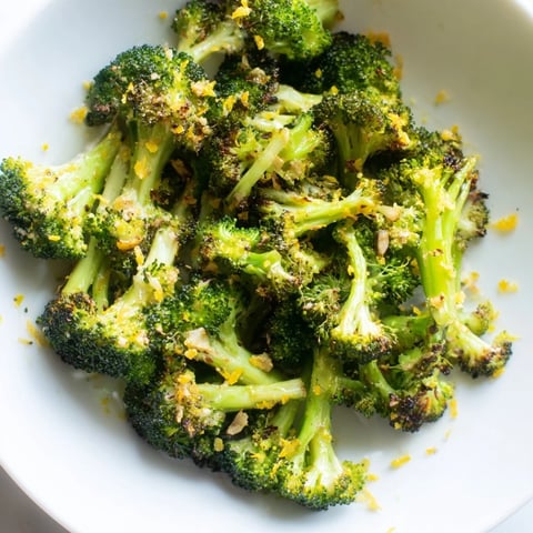 Tender Lemon Garlic Roasted Broccoli glistens on a baking sheet, ready to be served.