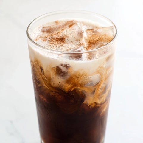 Creamy, iced Proffee Power Blend, ready to energize you, shows coffee swirling into vanilla protein.