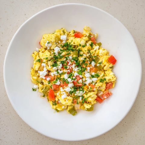 Golden Turkish Menemen scramble, a colorful medley of tomatoes, peppers, and fluffy eggs, ready to eat.