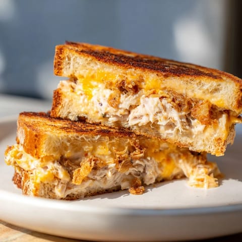 Close-up of a perfectly grilled Crispy Shallot Chicken Grilled Cheese, featuring crispy shallots.