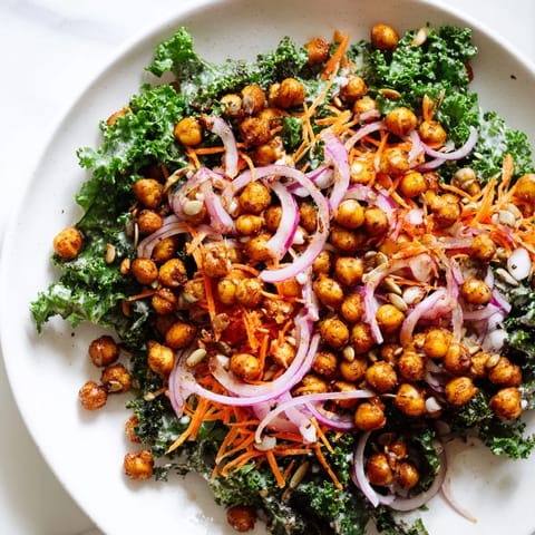 Freshly tossed kale salad with roasted chickpeas, featuring crunchy golden chickpeas on top.