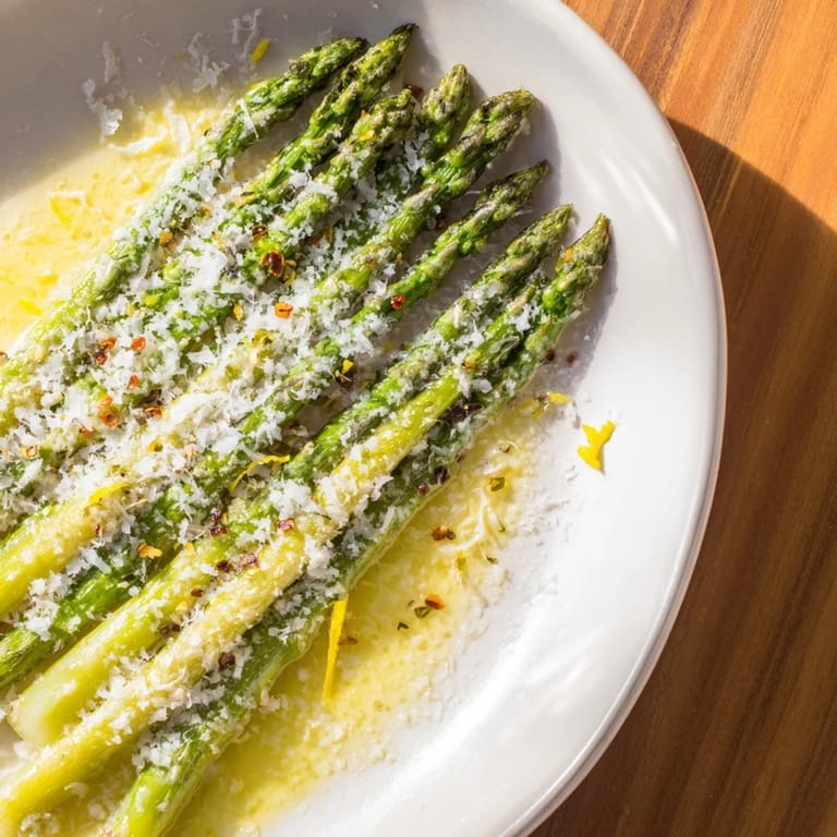 Freshly roasted Asparagus with a sprinkle of Parmesan, garnished with bright lemon zest for a dinner side.
